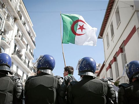 Police stand guard as students demonstrate in Algiers, Algeria, Tuesday, April 9, 2019. 
