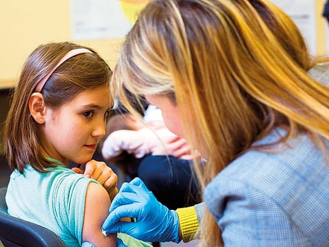 A 9-year-old rolls up her sleeve for a vaccination at a clinic in Portland. A measles outbreak continues to spread throughout the United States, new government data shows.