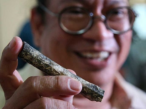 Filipino archeologist Armand Salvador Mijares shows a femur bone, one of those they recovered from Callao Cave belonging to a new specie they called Homo luzonensis, during a press conference in metropolitan Manila, Philippines.