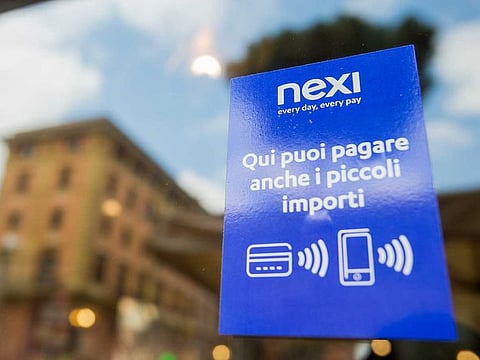 A sign at the entrance to a restaurant shows that payment services are provided by Nexi SpA in Rome, Italy.
