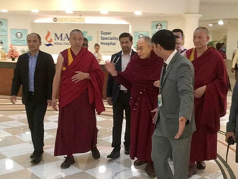 Tibetan spiritual leader the Dalai Lama, center, leaves from a hospital, in New Delhi, India.