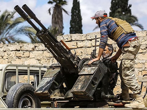 A man speaks to another sitting in a turret at a position held by forces loyal to Libya's Government of National Accord (GNA) in the suburb of Wadi Rabie about 30 kilometres south of the capital Tripoli 