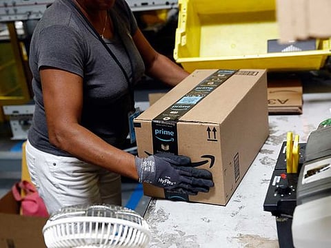 An Amazon employee applies tape to a package before shipment at an Amazon fulfillment center in Baltimore.