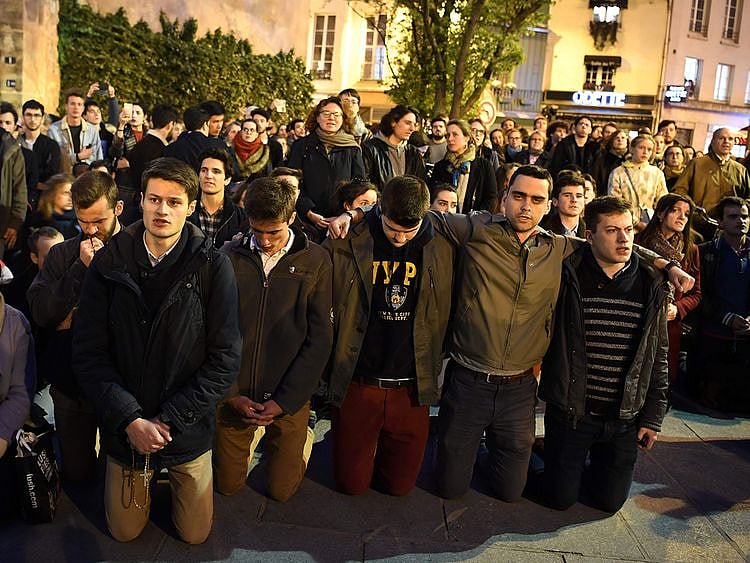 People kneel on the pavement