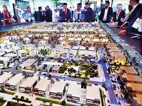 Visitors to Cityscape Abu Dhabi view a scale model of an Aldar project at Adnec. Aldar has raked in Dh2 billion from freehold plot sales and expects strong demand in the future.