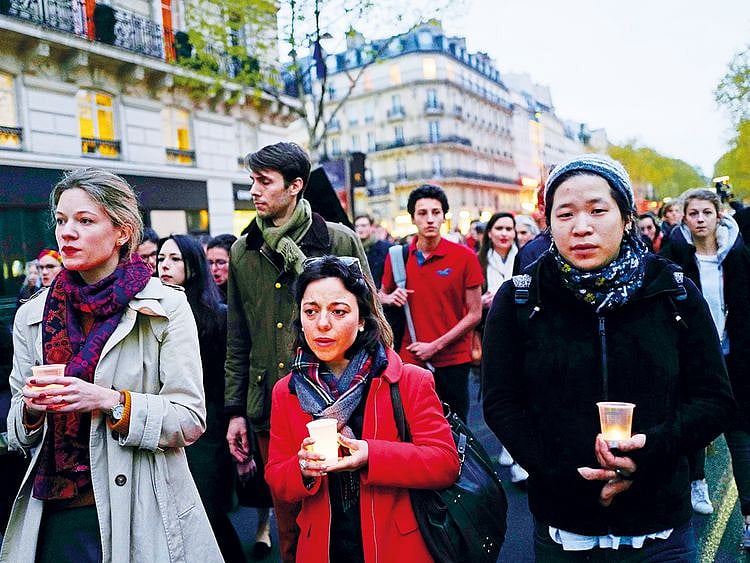 People walk toward the Notre Dame Cathedral to attend a vigil, in Paris