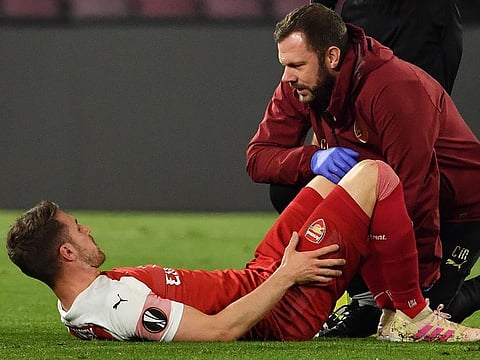 A staff medic tends to Arsenal's Welsh midfielder Aaron Ramsey after he was injured during the UEFA Europa League quarter-final second leg football match Napoli vs Arsenal on April 18, 2019 at the San Paolo stadium in Naples.