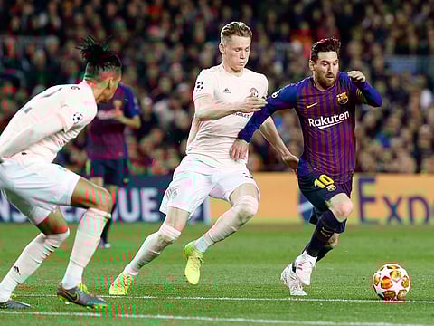Barcelona forward Lionel Messi, right, runs with the ball past Manchester United's Scott McTominay and  Chris Smalling.
