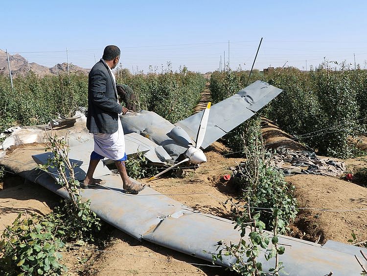 People inspect the wreckage of a drone aircraft