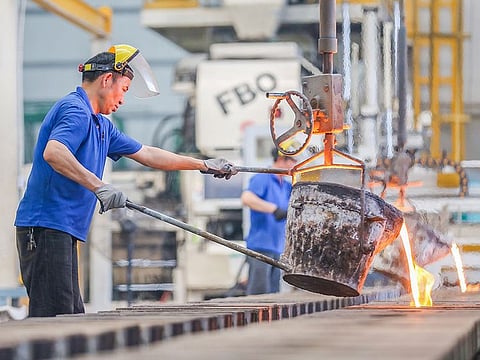 A Chinese employee pouring molten steel at a factory in Jinjiang in China's eastern Fujian province. 