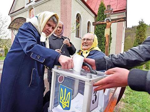 A local resident casts her vote into a mobile ballot box during the second round of a presidential election in the village of Maidan in Lviv Region, Ukraine April 21, 2019. 