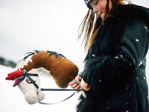 Fanny Oikarinen rides her hobbyhorse near her home in a village north of Helsinki.