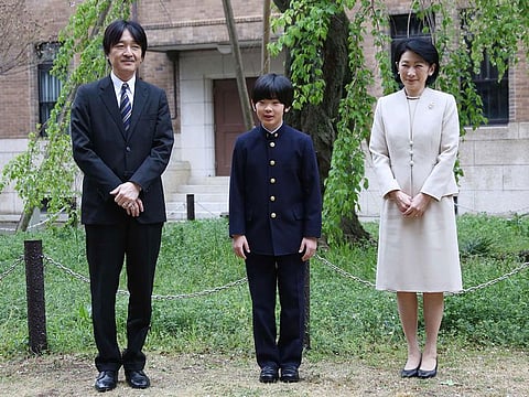 Japan's Prince Hisahito (C) and his parents Prince Akishino (L) and Princess Kiko (R) pose for photos at Ochanomizu University junior high school before attending the entrance ceremony in Tokyo.