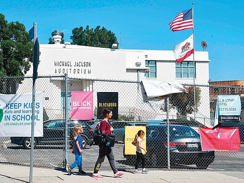 Pedestrians walk past the Michael Jackson Auditorium at Gardner Street Elementary school in Hollywood, California.