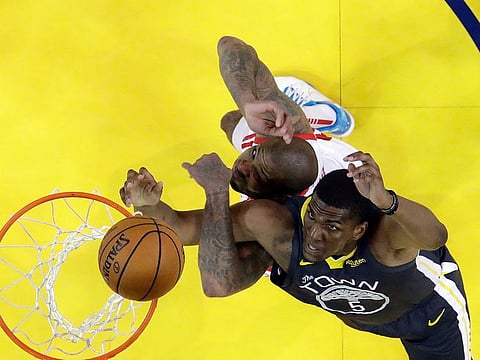 Golden State Warriors' Kevon Looney, bottom right, works for a rebound against Houston Rockets' PJ Tucker during the second half of Game 2 of a second-round NBA basketball playoff series in Oakland, California, on Tuesday, April 30, 2019. 