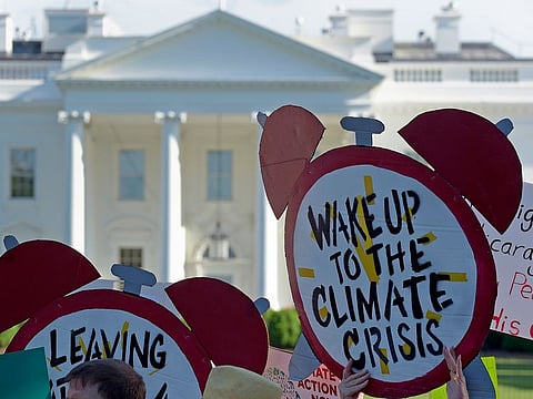 In this June 1, 2017 file photo, protesters gather outside the White House in Washington to protest President Donald Trump's decision to withdraw the Unites States from the Paris climate change accord.