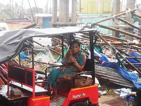 An Indian resident sits on an electric rickshaw next to a damaged structure after Cyclone Fani landfall in Puri in the eastern Indian state of Odisha on May 3, 2019.
