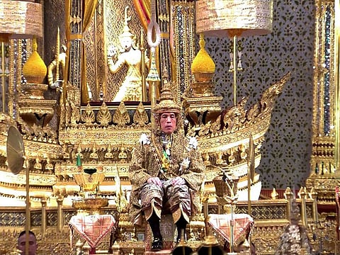 Thailand's King Maha Vajiralongkorn facing the audience wearing the gold crown while sitting on the throne during his coronation at the Grand Palace in Bangkok.  