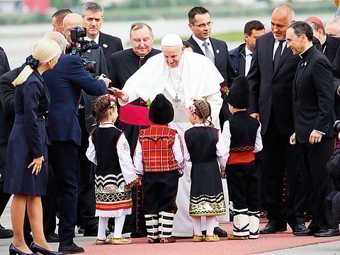 Pope Francis is welcomed by children wearing traditional dress upon his arrival in Sofia, Bulgaria, Sunday, May 5, 2019.