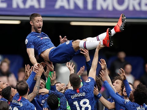 Chelsea's Gary Cahill, top center, is cheered by teammates.