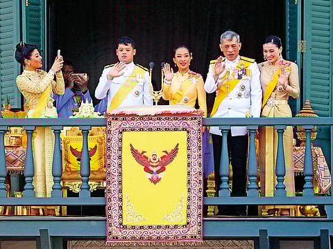 Princess Sirivannavari Nariratana, daughter, takes a photo of the royal family from second left; Prince Dipangkorn Rasmijoti, son, Princess Bajrakitiyabha, daughter, King Maha Vajiralongkorn and Queen Suthida wave to an audience from the balcony of Suddhaisavarya Prasad Hall in the Grand Palace during the coronation ceremony Monday, May 6, 2019, in Bangkok, Thailand.