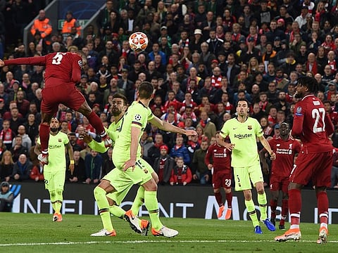 Liverpool midfielder Georginio Wijnaldum (L) heads the ball to score their third goal during the UEFA Champions league semi-final second leg football match between Liverpool and Barcelona at Anfield in Liverpool, north west England on May 7, 2019.  