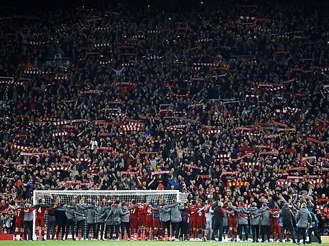 Liverpool players and fans celebrate after the match.               
