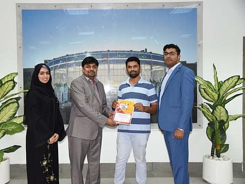 Manzoor Ali (second from right) holding his winning gift voucher with Dalma Mall management staff