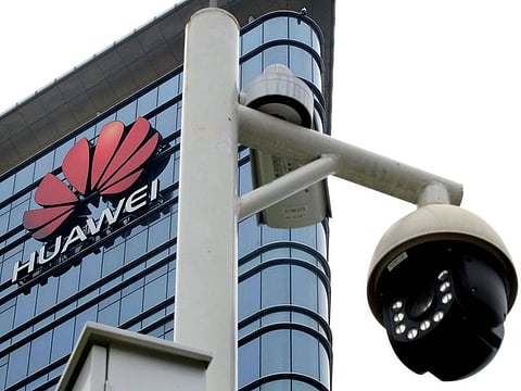 Surveillance cameras are seen in front of Huawei logo outside its factory campus in Dongguan, Guangdong province, China.