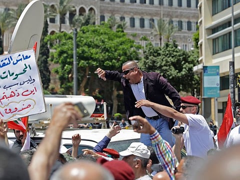 Lebanese army veterans react at the arrival of Lebanon's minister of defence during a demonstration near the governmental palace in Beirut on May 10, 2019 to protest legislation related to their pension entitlements thought to be voted in the upcoming government budget cuts.