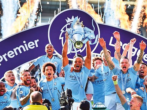 Manchester City’s Vincent Kompany lifts the Premier League trophy after their 4-1 victory over Brighton on Sunday.