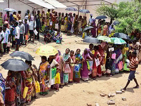 Indian residents queue to collect relief materials in Puri in the eastern Indian state of Odisha, following Cyclone Fani.