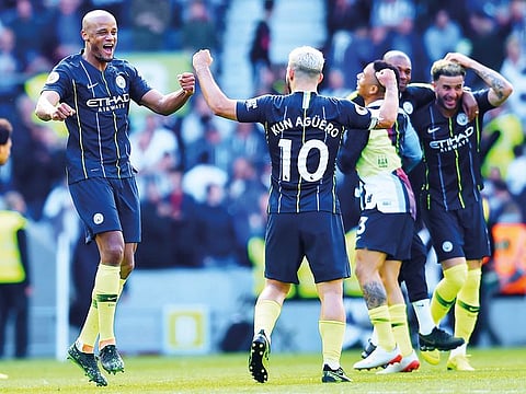 Manchester City's Sergio Aguero (2L) and Vincent Kompany (L) celebrate at the final whistle of the English Premier League football match between Brighton and Hove Albion and Manchester City at the American Express Community Stadium in Brighton, southern England on May 12, 2019. 