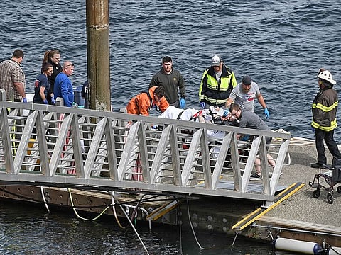 Emergency response crews transport an injured passenger to an ambulance at the George Inlet Lodge docks, Monday, May 13, 2019, in Ketchikan, Alaska. 