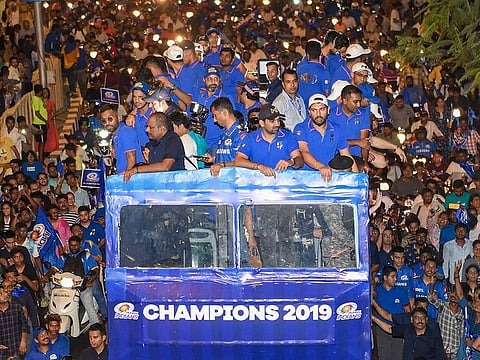 Mumbai Indians (MI) players travel atop an open bus during a celebration procession, after winning the IPL 2019 trophy by defeating Chennai Super Kings (CSK), in Mumbai, Monday, May 13, 2019.  