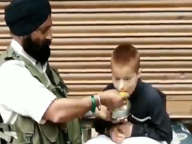 RDS_190514 Cop feeding boy-1557814216083