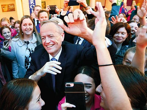 Australian opposition leader Bill Shorten is surrounded by students during a visit to St. Joseph’s Catholic College in Gosford on Monday. A federal election will be held in Australian on Saturday.