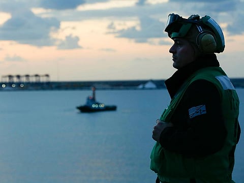 Aviation Maintenance Administrationman 2nd Class Jason Caldwell, assigned to the "Jolly Rogers" of Strike Fighter Squadron 103, observes sunrise on the flight deck of the Nimitz-class aircraft carrier USS Abraham Lincoln while transiting the Suez Canal in Egypt. The aircraft carrier and its strike group are deploying to the Arabian Gulf on orders from the White House to respond to an unspecified threat from Iran