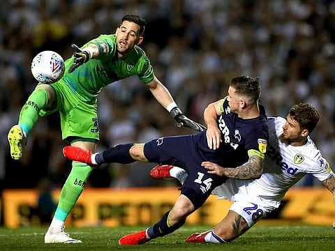Leeds United goalkeeper Kiko Casilla, left, attempts to collect the ball from Derby County's Jack Marriott and Leeds United's Gaetano Berardi.