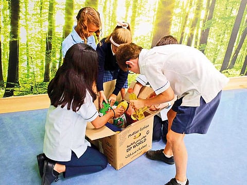 KG to Secondary students of Uptown School, Dubai, filling boxes with donated items for the Ramadan Box Project.