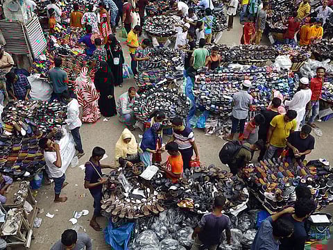People gather at a street shoe market in Dhaka, Bangladesh. As India’s growth falls, amongst the most in the world, India is on track to fall below Bangladesh in terms of the per capita GDP. 