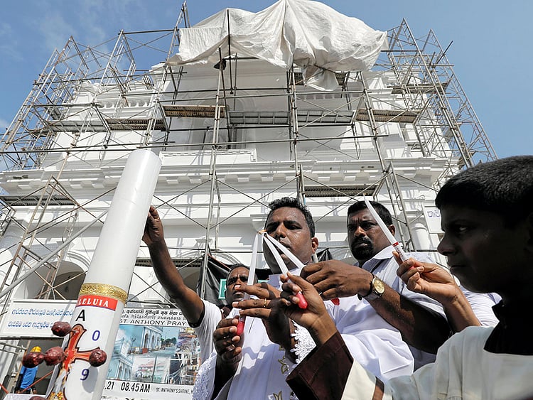 A priest blesses outside St Anthony's church