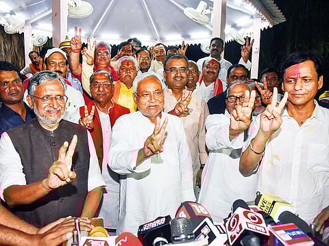 Bihar Chief Minister Nitish Kumar with his deputy Sushil Kumar Modi and supporters flash the victory sign after NDA’s win.
