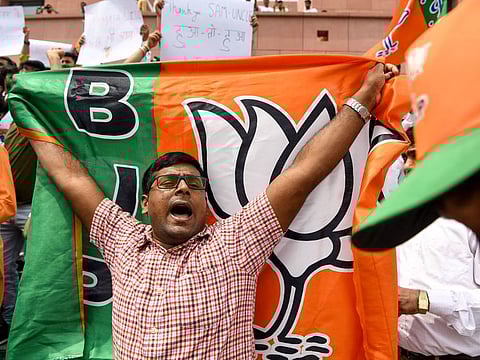 A Bharatiya Janata Party (BJP) supporter shouts slogans and holds the party flag in New Delhi, India.