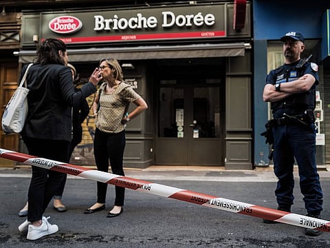 A police officer stands next to a perimeter set in front a 'Brioche doree' bakery before French Mayor of Lyon's visit on May 25, 2019 the day after a suspected package bomb blast along a pedestrian street in the heart of Lyon, southeast France. 