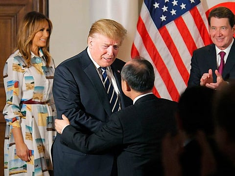US President Donald Trump, center left, greets SoftBank Group Corp.'s Chief Executive Masayoshi Son, center right,  as first lady Melania Trump, left, and U.S. Ambassador to Japan William Hagerty looks on during his meeting with business leaders, in Tokyo, Saturday, May 25, 2019.  President Trump is on a four-day state visit in Japan. 