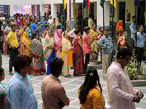 Indians stand in a queue to cast their votes, in New Delhi, India.