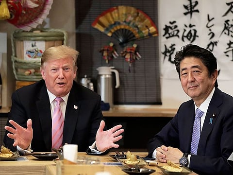 US President Donald Trump, left, speaks as Shinzo Abe, Japan's prime minister, sits at a counter during a dinner at the Inakaya restaurant in the Roppongi district of Tokyo, Japan, on Sunday, May 26, 2019. 