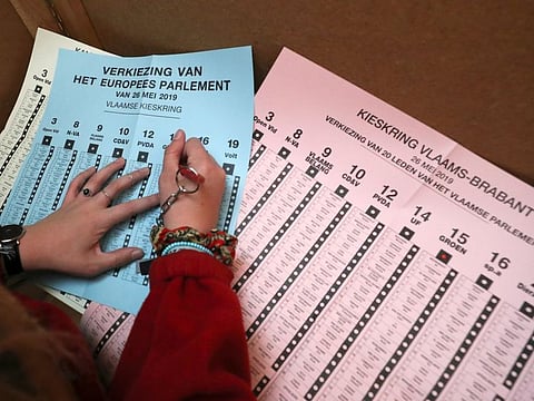 A woman prepares to cast her vote during Belgian general and regional elections and European Parliament Elections in Sint-Pieters-Leeuw, Belgium on May 26, 2019. 