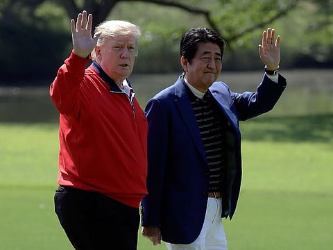 President Donald Trump and Japanese Prime Minister Shinzo Abe wave before playing a round of golf at Mobara Country Club, Sunday, May 26, 2019, in Chiba, Japan.